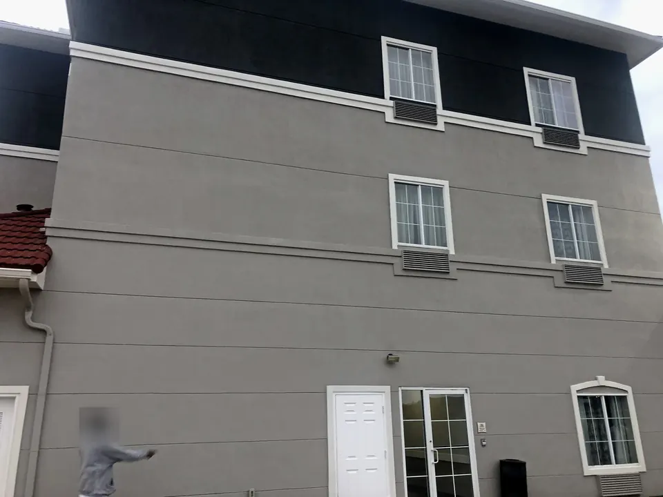 After: close view of the repainted stucco wall and white window trim