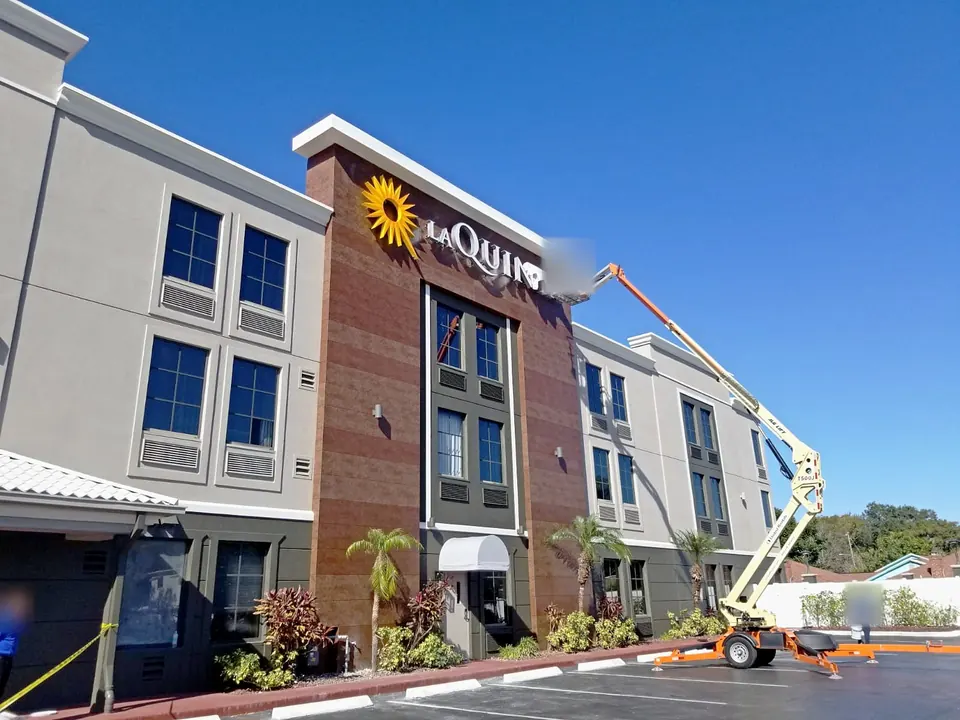 Facade work from a boom lift at the hotel sign