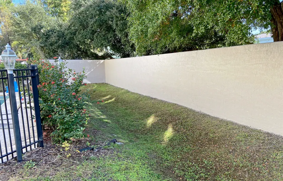Painted perimeter wall along the lawn